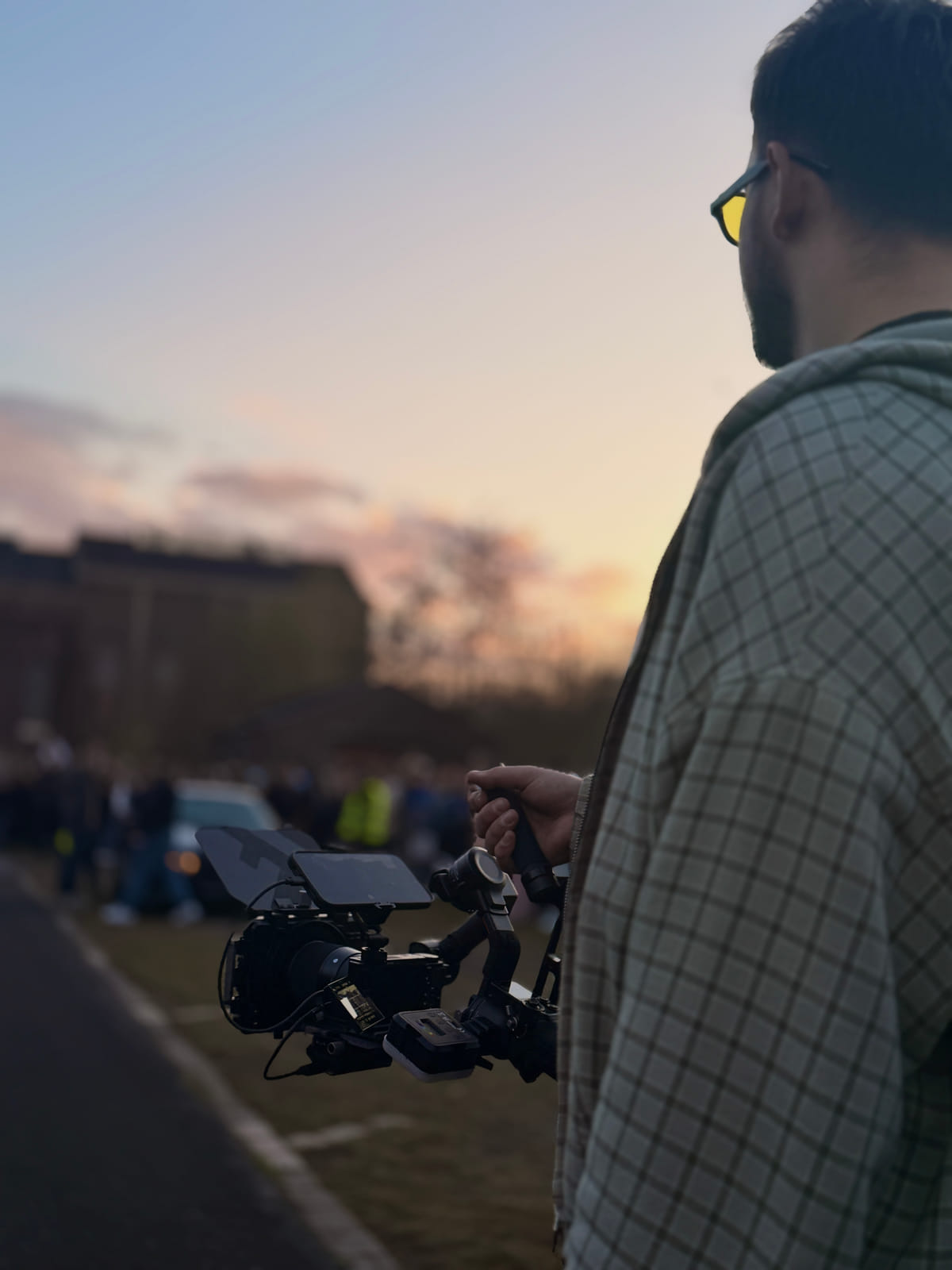 Kameramann mit Gimbal in der Abenddämmerung bei einem Car-Meet